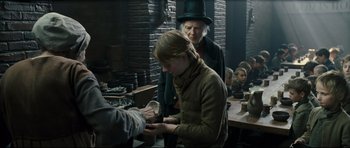 Movie still from “Oliver Twist” (2005), directed by Roman Polanski – An old man and a young girl in a room; Medium shot, Over the shoulder angle