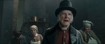 An old man and a woman standing in front of a stove