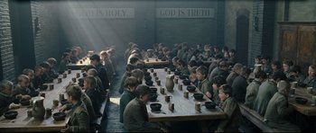 Movie still from “Oliver Twist” (2005), directed by Roman Polanski – A group of people sitting around a long table; Wide shot, High angle