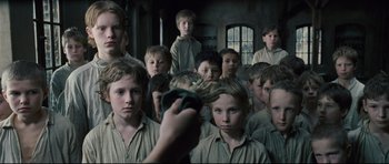 Movie still from “Oliver Twist” (2005), directed by Roman Polanski – A group of young boys in a room; Medium shot, Over the shoulder angle