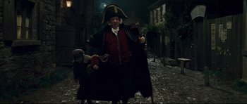 Movie still from “Oliver Twist” (2005), directed by Roman Polanski – A man dressed as a pirate standing in the middle of a street; Medium shot, Low angle