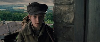 Movie still from “Oliver Twist” (2005), directed by Roman Polanski – A young boy wearing a hat and a coat; Close Up shot, Low angle
