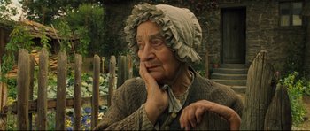 Movie still from “Oliver Twist” (2005), directed by Roman Polanski – An old woman wearing a hat is sitting down; Close Up shot, Over the shoulder angle