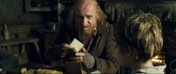 Movie still from “Oliver Twist” (2005), directed by Roman Polanski – A man with a beard is holding an envelope; Medium shot, Over the shoulder angle