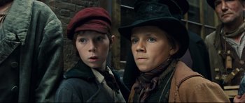 Movie still from “Oliver Twist” (2005), directed by Roman Polanski – Two young boys dressed up in hats and ties; Close Up shot, Low angle