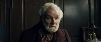 Movie still from “Oliver Twist” (2005), directed by Roman Polanski – An old man with white hair and a white beard; Close Up shot, Low angle