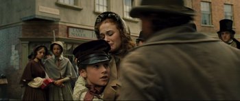 Movie still from “Oliver Twist” (2005), directed by Roman Polanski – A woman and a boy wearing a hat and a jacket; Close Up shot, Over the shoulder angle