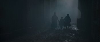 Movie still from “Oliver Twist” (2005), directed by Roman Polanski – A group of people walking in the dark; Wide shot, High angle
