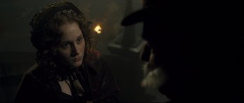 Movie still from “Oliver Twist” (2005), directed by Roman Polanski – A young woman sitting in front of a bearded man; Close Up shot, Over the shoulder angle