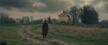 Movie still from “Oliver Twist” (2005), directed by Roman Polanski – An old man standing on a dirt road in front of an abandoned house; Extreme Wide shot, Low angle