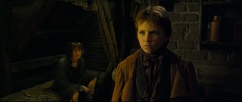 Movie still from “Oliver Twist” (2005), directed by Roman Polanski – A boy in a brown jacket and a girl in a brown jacket; Medium shot, Low angle