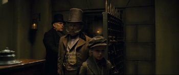 Movie still from “Oliver Twist” (2005), directed by Roman Polanski – A man and a boy dressed up in costume; Medium shot, Low angle