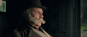 Movie still from “Oliver Twist” (2005), directed by Roman Polanski – An old man with a long mustache and a hat; Close Up shot, Over the shoulder angle