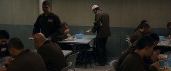 Movie still from “Omar” (2013), directed by Hany Abu-Assad – A group of men standing around a table with food; Wide shot, High angle