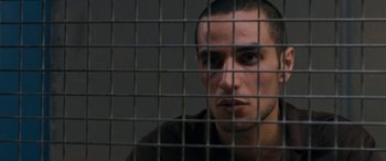 Movie still from “Omar” (2013), directed by Hany Abu-Assad – A person behind a metal fence; Close Up shot, Over the shoulder angle