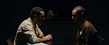 Movie still from “Omar” (2013), directed by Hany Abu-Assad – Two men sitting at a table talking to each other; Medium shot, Over the shoulder angle