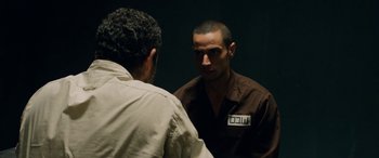 Movie still from “Omar” (2013), directed by Hany Abu-Assad – A man in a brown shirt is talking to another man in a brown shirt; Medium shot, Over the shoulder angle