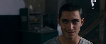 Movie still from “Omar” (2013), directed by Hany Abu-Assad – A person smiling for the camera; Close Up shot, Low angle