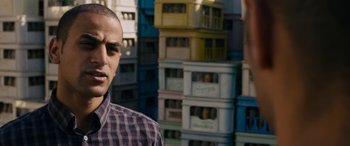 Movie still from “Omar” (2013), directed by Hany Abu-Assad – A man standing in front of a bunch of boxes; Close Up shot, Low angle