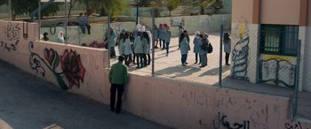Movie still from “Omar” (2013), directed by Hany Abu-Assad – A group of people standing in front of a fence; Extreme Wide shot, High angle