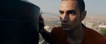 Movie still from “Omar” (2013), directed by Hany Abu-Assad – A person holding a metal pole; Close Up shot, Low angle