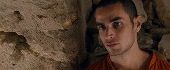 Movie still from “Omar” (2013), directed by Hany Abu-Assad – A person with a brick wall in the background; Close Up shot, Over the shoulder angle