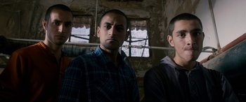 Movie still from “Omar” (2013), directed by Hany Abu-Assad – Two men standing next to each other in a room; Medium shot, Low angle