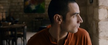 Movie still from “Omar” (2013), directed by Hany Abu-Assad – A person wearing an orange shirt; Close Up shot, Over the shoulder angle