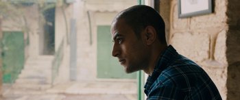 Movie still from “Omar” (2013), directed by Hany Abu-Assad – A person looking out of a window; Close Up shot, Low angle