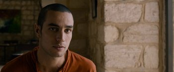 Movie still from “Omar” (2013), directed by Hany Abu-Assad – A young man with a shaved head is posing for a picture; Close Up shot, Over the shoulder angle