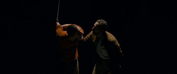 Movie still from “Omar” (2013), directed by Hany Abu-Assad – Two men are fighting in the dark with one holding a sword; Medium shot, Low angle