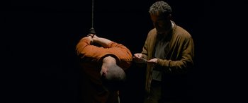 Movie still from “Omar” (2013), directed by Hany Abu-Assad – A man hanging from a rope with another man holding a knife; Medium shot, Low angle