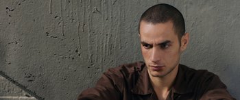 Movie still from “Omar” (2013), directed by Hany Abu-Assad – A person wearing a brown shirt; Close Up shot, Over the shoulder angle