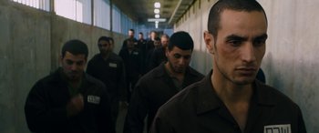 Movie still from “Omar” (2013), directed by Hany Abu-Assad – A group of men are walking down a long hallway; Close Up shot, Over the shoulder angle