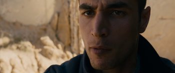 Movie still from “Omar” (2013), directed by Hany Abu-Assad – Close up of a man's face in front of a rock wall; Close Up shot, Low angle
