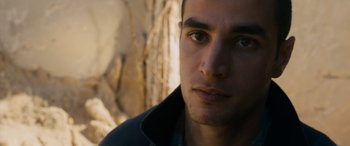 Movie still from “Omar” (2013), directed by Hany Abu-Assad – A man's face in front of a stone wall; Close Up shot, Over the shoulder angle