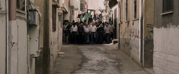 Movie still from “Omar” (2013), directed by Hany Abu-Assad – A group of people walking down a street; Extreme Wide shot, High angle