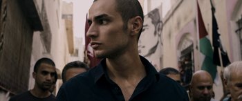 Movie still from “Omar” (2013), directed by Hany Abu-Assad – A person wearing a black shirt; Close Up shot, Low angle