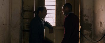 Movie still from “Omar” (2013), directed by Hany Abu-Assad – Two men standing next to each other near a window; Medium shot, Over the shoulder angle
