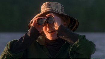 Movie still from “On Golden Pond” (1981), directed by Mark Rydell – A woman looking through binoculars while wearing a hat; Close Up shot, Over the shoulder angle
