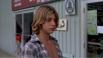 Movie still from “On Golden Pond” (1981), directed by Mark Rydell – A young man with long hair and a plaid shirt; Close Up shot, Low angle
