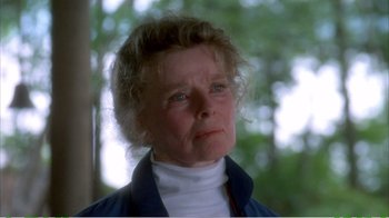 Movie still from “On Golden Pond” (1981), directed by Mark Rydell – An older woman looking off into the distance with trees in the background; Close Up shot, Low angle