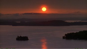 Movie still from “On Golden Pond” (1981), directed by Mark Rydell – The sun is setting over a body of water; Extreme Wide shot, High angle