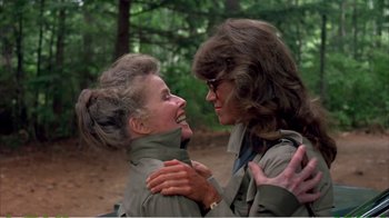 Movie still from “On Golden Pond” (1981), directed by Mark Rydell – A woman and a man hugging in a wooded area; Medium shot, Over the shoulder angle