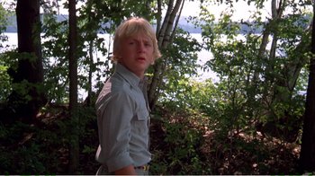 Movie still from “On Golden Pond” (1981), directed by Mark Rydell – A young man standing in front of some trees; Medium shot, Low angle