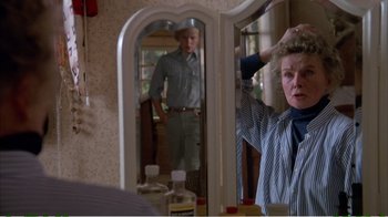 Movie still from “On Golden Pond” (1981), directed by Mark Rydell – A man standing in front of a mirror in front of a woman; Medium shot, Over the shoulder angle