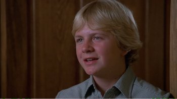 Movie still from “On Golden Pond” (1981), directed by Mark Rydell – A young man with blonde hair and a checkered shirt; Close Up shot, High angle