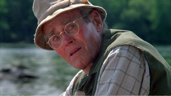 Movie still from “On Golden Pond” (1981), directed by Mark Rydell – An older man wearing a hat and glasses; Close Up shot, Over the shoulder angle