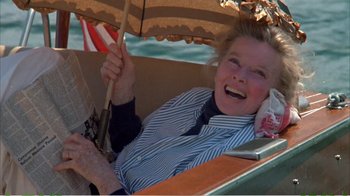 Movie still from “On Golden Pond” (1981), directed by Mark Rydell – An older woman holding an umbrella while sitting in a boat; Medium shot, High angle