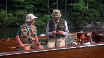 Movie still from “On Golden Pond” (1981), directed by Mark Rydell – A man sitting on the back of a boat with a woman; Wide shot, High angle
